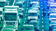 Trucks, cars and a biker drive on a highway in Frankfurt, February 204