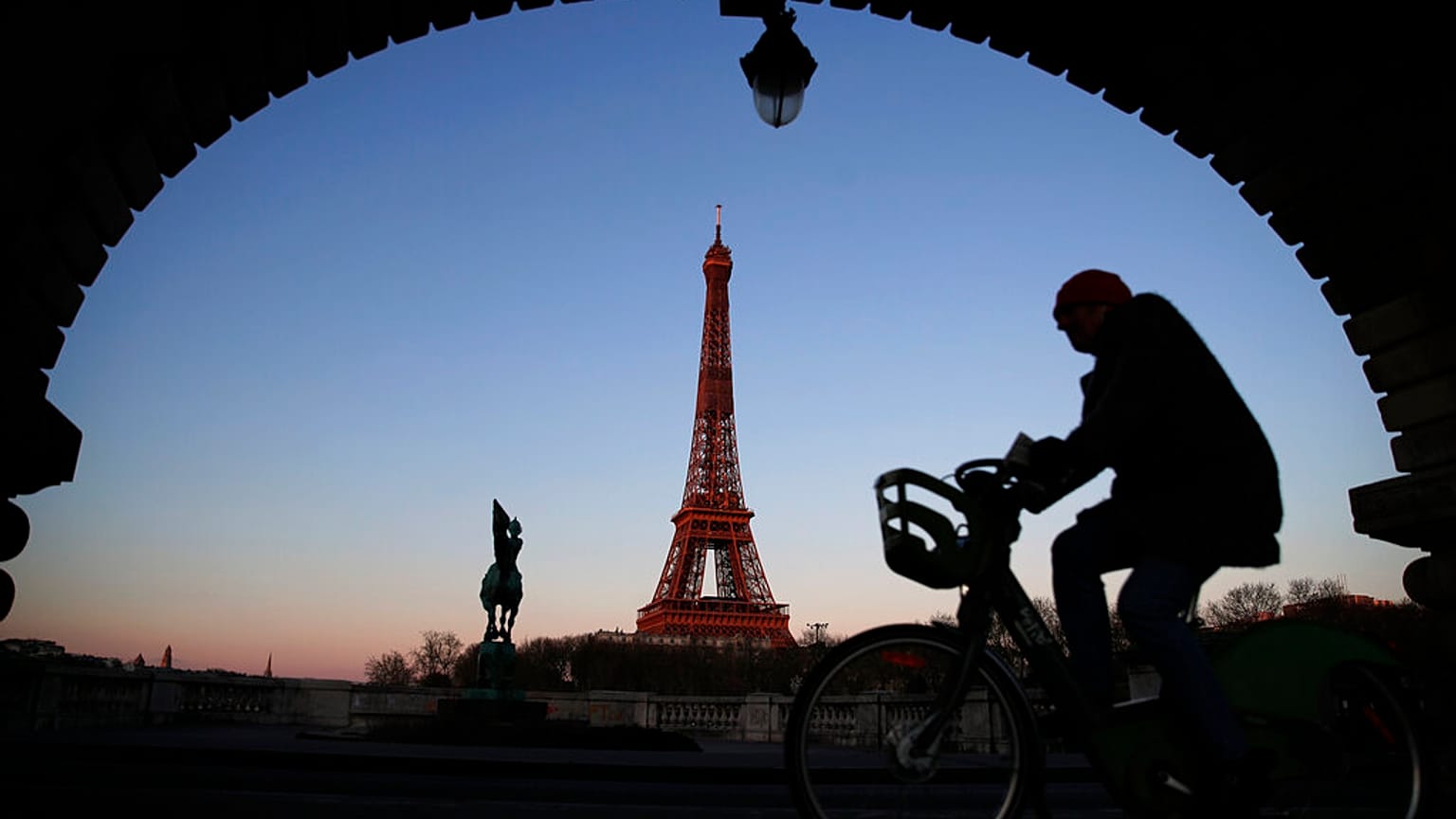 A man rides on a city bicycle in Paris, Monday, March 30, 2020.
