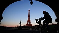 A man rides on a city bicycle in Paris, Monday, March 30, 2020.