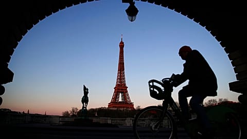 A man rides on a city bicycle in Paris, Monday, March 30, 2020.