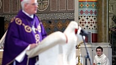 A alter boy listens to Bishop Noel Treanor, during mass at St Peter's Roman Catholic Cathedral in West Belfast, Northern Ireland, Sunday, March, 21, 2010. 