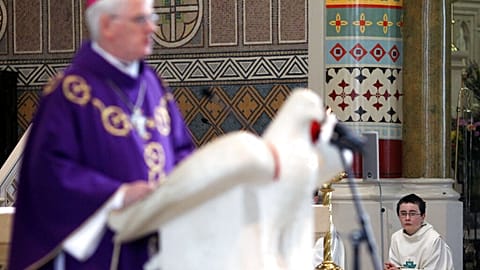 A alter boy listens to Bishop Noel Treanor, during mass at St Peter's Roman Catholic Cathedral in West Belfast, Northern Ireland, Sunday, March, 21, 2010. 