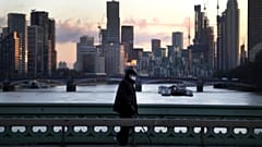 A man walks over Westminster Bridge as the sun sets in London, January 6, 2021