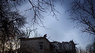 A Ukrainian serviceman stands atop a damaged kindergarten following a Russian drone attack in Kyiv, Ukraine, Saturday, Nov. 25, 2023.