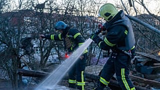 Rescuers working to extinguish a fire at the site of a drone attack in Kyiv, 25 November 2023