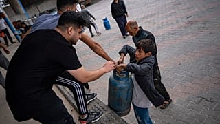 Palestinianos fazem fila para encher botijas de gás, durante cessar-fogo, em Khan Younis, na Faixa de Gaza