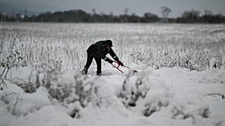 A local resident clears snow from a path after heavy snowfall, on the outskirts of Sofia, Bulgaria on Sunday