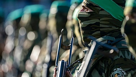 Militants stand guard around the stage as Yahya Sinwar, Palestinian leader of Hamas in the Gaza Strip, attends a rally of supporters, May 24, 2021, in Gaza City.