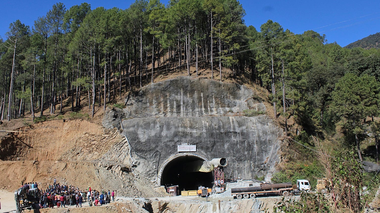 Menschen beobachten Rettungs- und Hilfsmaßnahmen an der Stelle eines im Bau befindlichen Straßentunnels, der im indischen Bundesstaat Uttarakhand eingestürzt ist, 