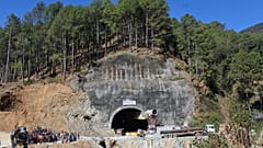 Menschen beobachten Rettungs- und Hilfsmaßnahmen an der Stelle eines im Bau befindlichen Straßentunnels, der im indischen Bundesstaat Uttarakhand eingestürzt ist, 