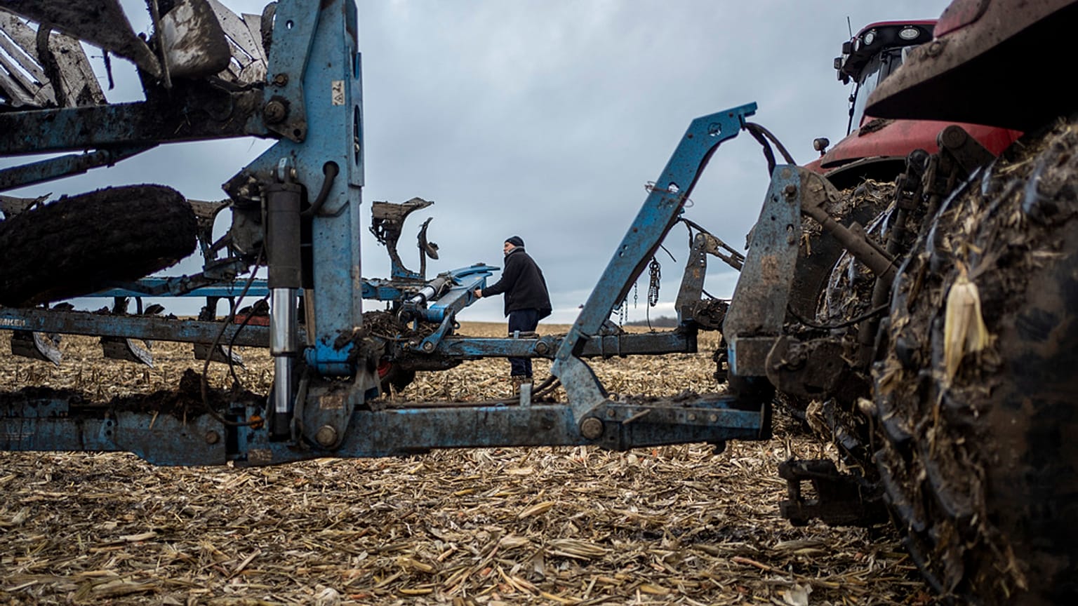 A farmer operates a tractor at a cornfield in Sumy region, Ukraine