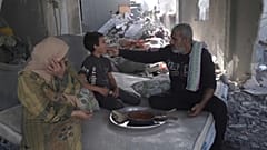 عائلة فلسطينية تتغذى على وجبة من الطماطم والخبز في غزة