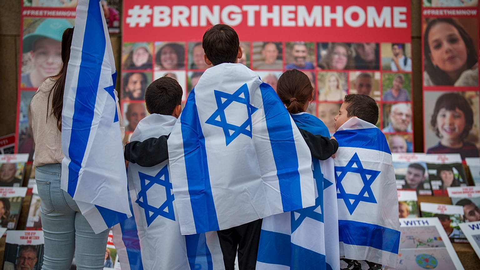 FILE - Children look at photographs of kidnapped Israelis during a rally joined by hundreds in solidarity with Israel and those held hostage in Gaza, in Romania 2/11/23.