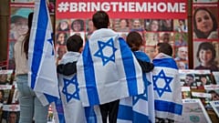 FILE - Children look at photographs of kidnapped Israelis during a rally joined by hundreds in solidarity with Israel and those held hostage in Gaza, in Romania 2/11/23.