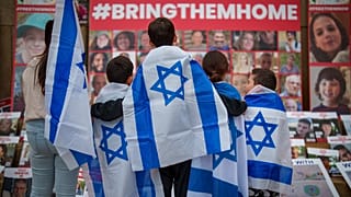FILE - Children look at photographs of kidnapped Israelis during a rally joined by hundreds in solidarity with Israel and those held hostage in Gaza, in Romania 2/11/23.