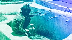 A displaced child fills a jug with water in al-Hasahisa south of Khartoum, July 2023