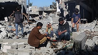 Los palestinos cocinan pan junto a sus casas destruidas en Kuza'a, Franja de Gaza, durante el alto el fuego temporal entre Hamás e Israel el miércoles 29 de noviembre de 2023.