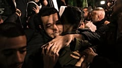 A man smiles as he is welcomed after being released from prison by Israel, in the West Bank town of Ramallah, early Thursday, Nov. 30, 2023. 