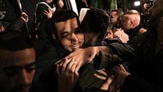 A man smiles as he is welcomed after being released from prison by Israel, in the West Bank town of Ramallah, early Thursday, Nov. 30, 2023. 