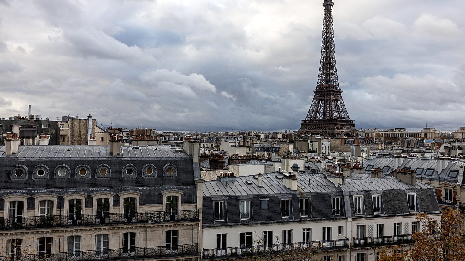 Cette photographie prise le 21 novembre 2023 montre la Tour Eiffel au-dessus des toits de Paris.