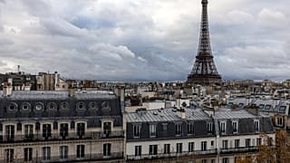 This photograph taken on November 21, 2023 shows the Eiffel Tower above the rooftops of Paris.