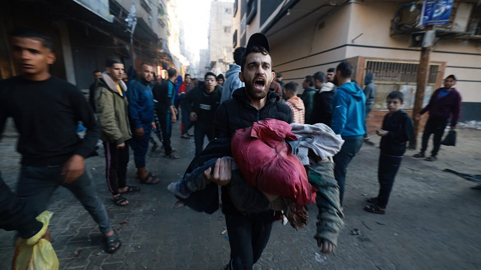 Civili palestinesi che corrono per mettersi al riparo dagli attacchi aerei israeliani a Rafah