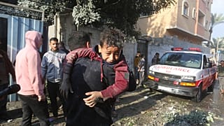 سيارة إسعاف تصل إلى مكان استهدفه القصف الإسرائيلي في رفح بينما يقوم السكان بإخلاء الجرحى 1/12/2023