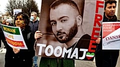 A woman holds a poster of rapper Toomaj Salehi, who was arrested over his support of the Mahsa Amini protests
