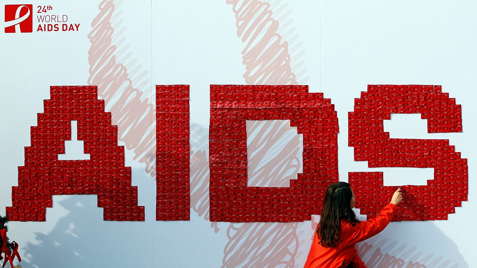 Bir kadın 2011 yılında Güney Kore'de düzenlenen bir AIDS farkındalık kampanyası sırasında panoya prezervatif takıyor.