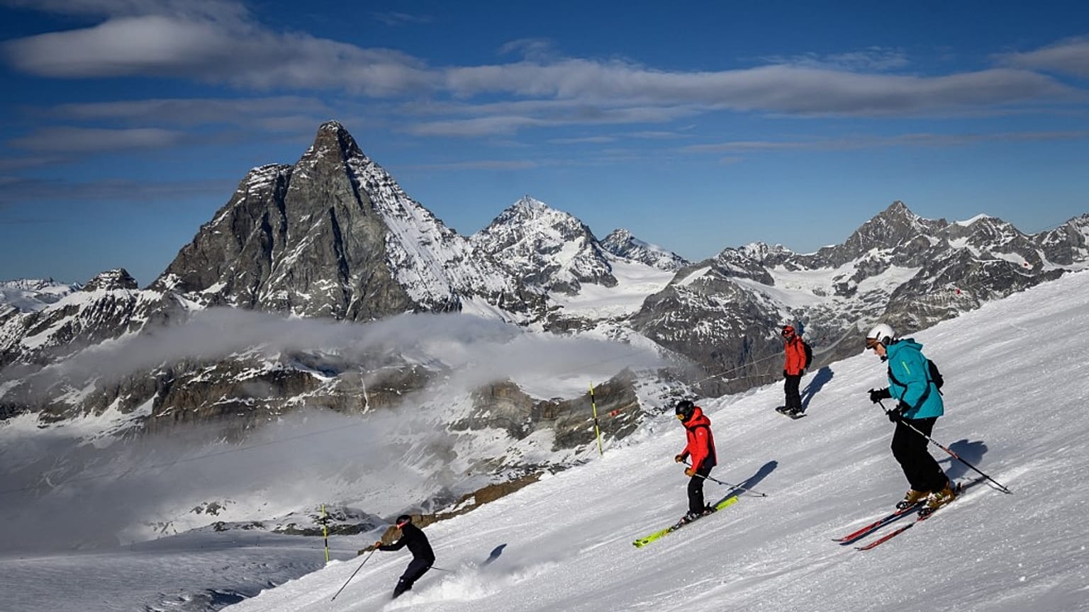 Skiers with the Matterhorn mountain as landscape near the 3,480-metre high Rifugio Guide del Cervino 