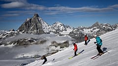 Skiers with the Matterhorn mountain as landscape near the 3,480-metre high Rifugio Guide del Cervino 