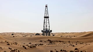 An oil drill pump amidst the sand dunes in the desert of the Gulf emirate of Dubai.