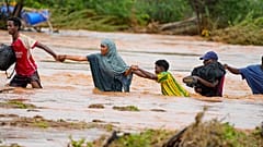  يعبر السكان طريقاً تضررت بسبب أمطار النينيو في كينيا