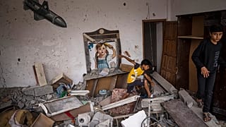 Gazze Şeridi'nden duvarında roket boyaması olan İsrail tarafından vurulan bir evde oynayan çocuklar.