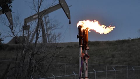 FILE - A flare to burn methane from oil production is seen on a well pad, Aug. 26, 2021, near Watford City, USA