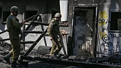 صورة تم التقاطها خلال جولة إعلامية نظمها الجيش الإسرائيلي تظهر جنودًا بالقرب من منزل متضرر في كيبوتس نير عوز جراء هجوم حركة حماس