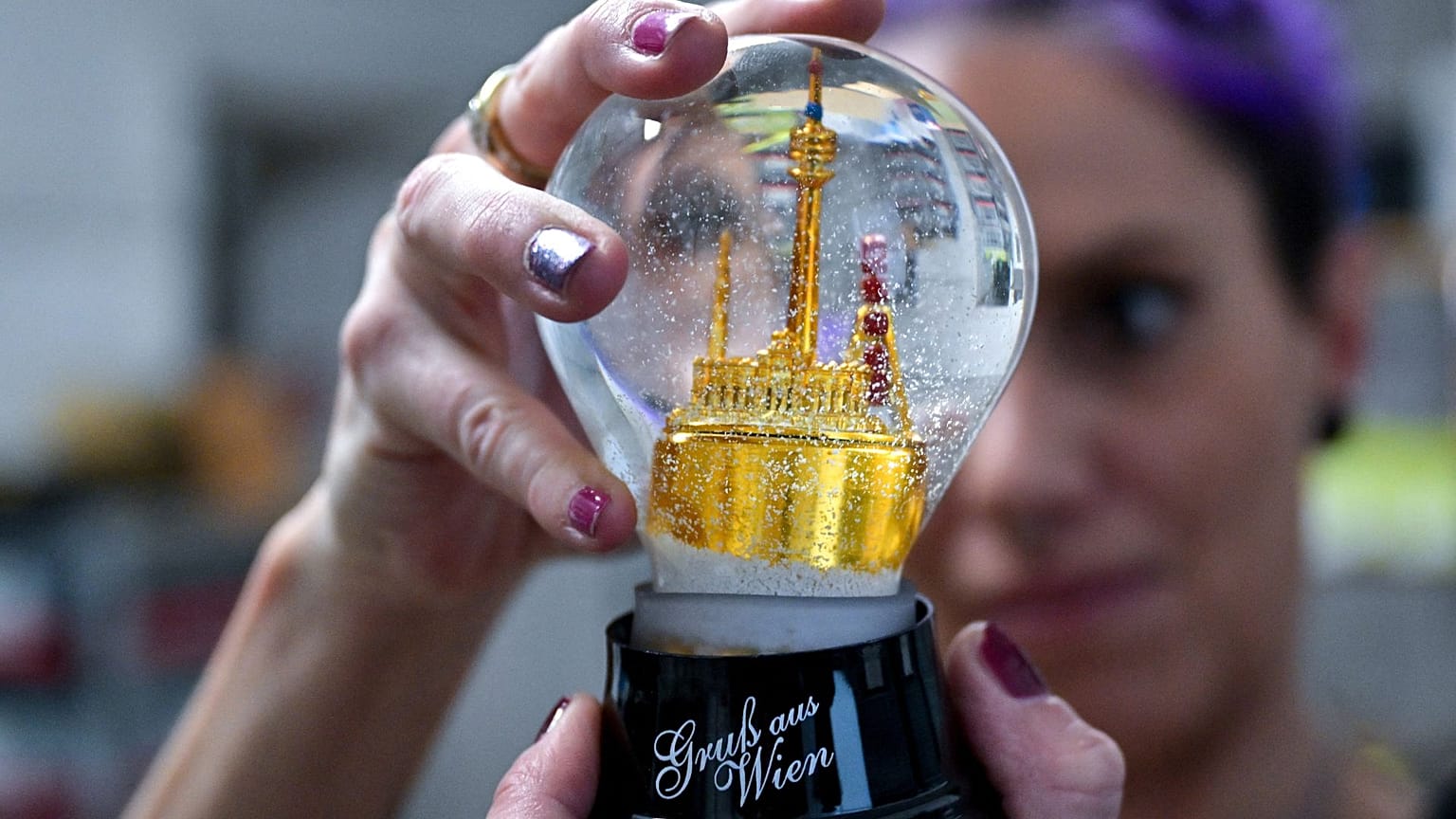 Tatjana, an employee of the 'Original Vienna Snowglobe Factory', assembles a snowglobe in Vienna, Austria on November 29, 2023.