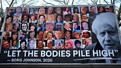 Carrinha mostra cartaz de protesto conta a gestão da pandemia por Boris Johnson