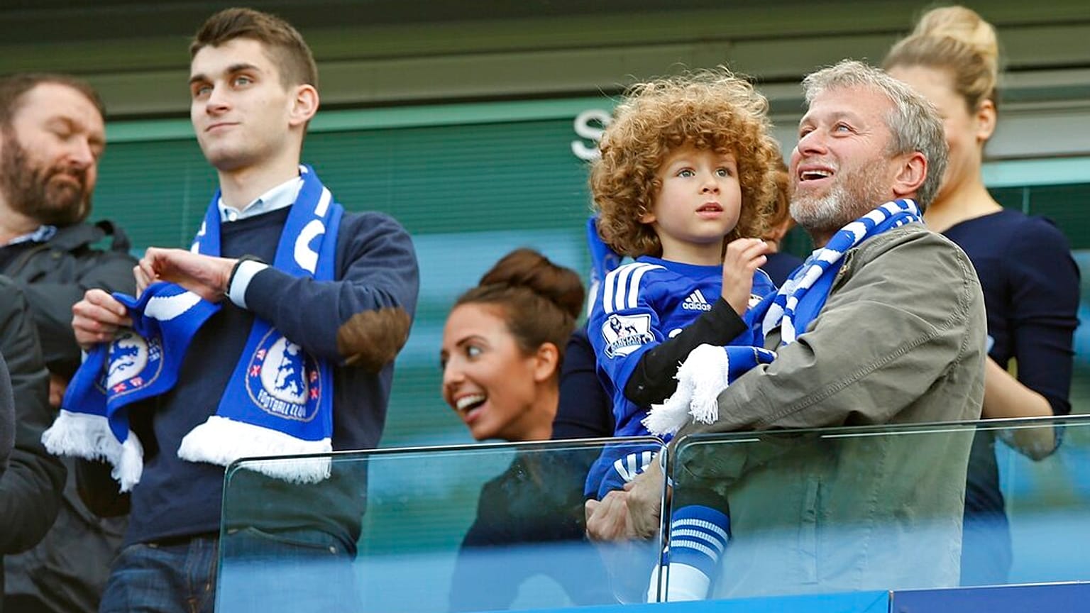 Chelsea owner Roman Abramovich smiles as he holds his son Aaron as his other son Arkadiy looks on at left after the English Premier League soccer match.