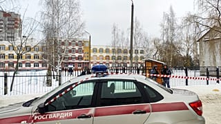Law enforcement officers stand guard outside Gymnasium Number Five following a shooting, in Bryansk on Thursday