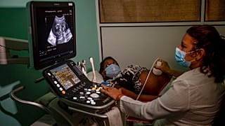 Hamile bir kadını ultrasona ile inceleyen bir doktor (arşiv)