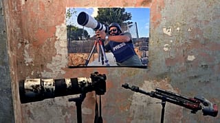 Lübnan'da İsrail tankından açılan ateşle 13 Ekim'de öldürülen Reuters kameramanı İssam Abdullah'ın posteri, kana bulanan fotoğraf makines, ve tripodu