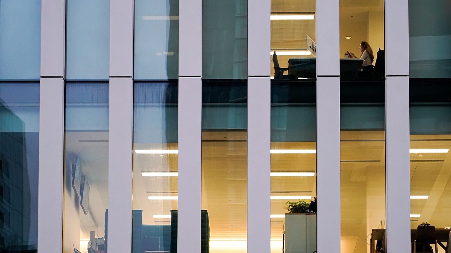A worker sits in an office in the financial district in London