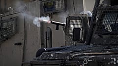 ضابط إسرائيلي يطلق الغاز المسيل للدموع على فلسطينيين خلال عملية عسكرية في مخيم بلاطة للاجئين بالضفة الغربية.