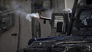 ضابط إسرائيلي يطلق الغاز المسيل للدموع على فلسطينيين خلال عملية عسكرية في مخيم بلاطة للاجئين بالضفة الغربية.