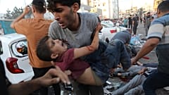 Ein verletzter palästinensischer Junge wird nach einem israelischen Luftangriff vor dem Eingang des Al-Shifa-Krankenhauses in Gaza-Stadt vom Boden getragen, Freitag, 3\. November 2023\. 
