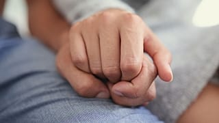 Duas pessoas de mãos dadas.