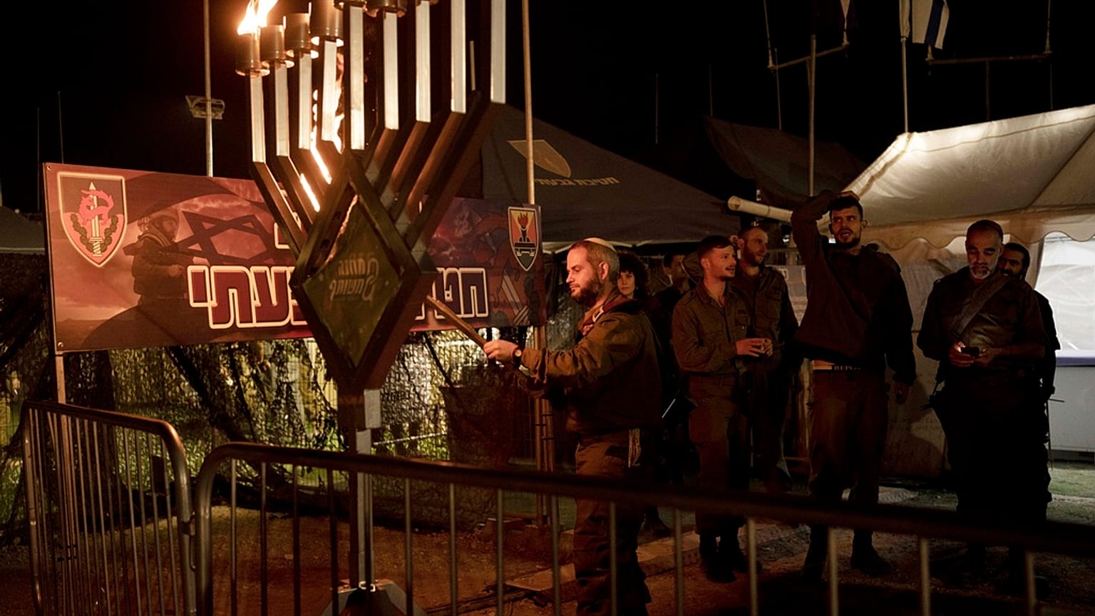  Israeli soldiers from the Givati Brigade mark the first night of the Jewish holiday of Hanukkah by lighting the first candle on their base in southern Israel