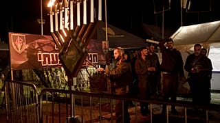  Israeli soldiers from the Givati Brigade mark the first night of the Jewish holiday of Hanukkah by lighting the first candle on their base in southern Israel