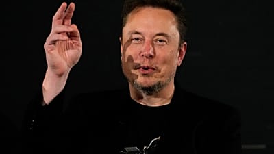 Elon Musk Kasım 2023'te Londra'da düzenlenen bir etkinlik sırasında eliyle işaret ediyor.